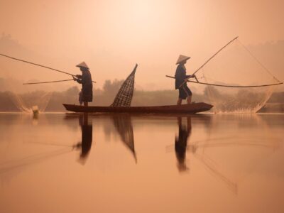 Two fishermen are fishing on the boat at Mekong river in the morning in Nong Khai, Thailand