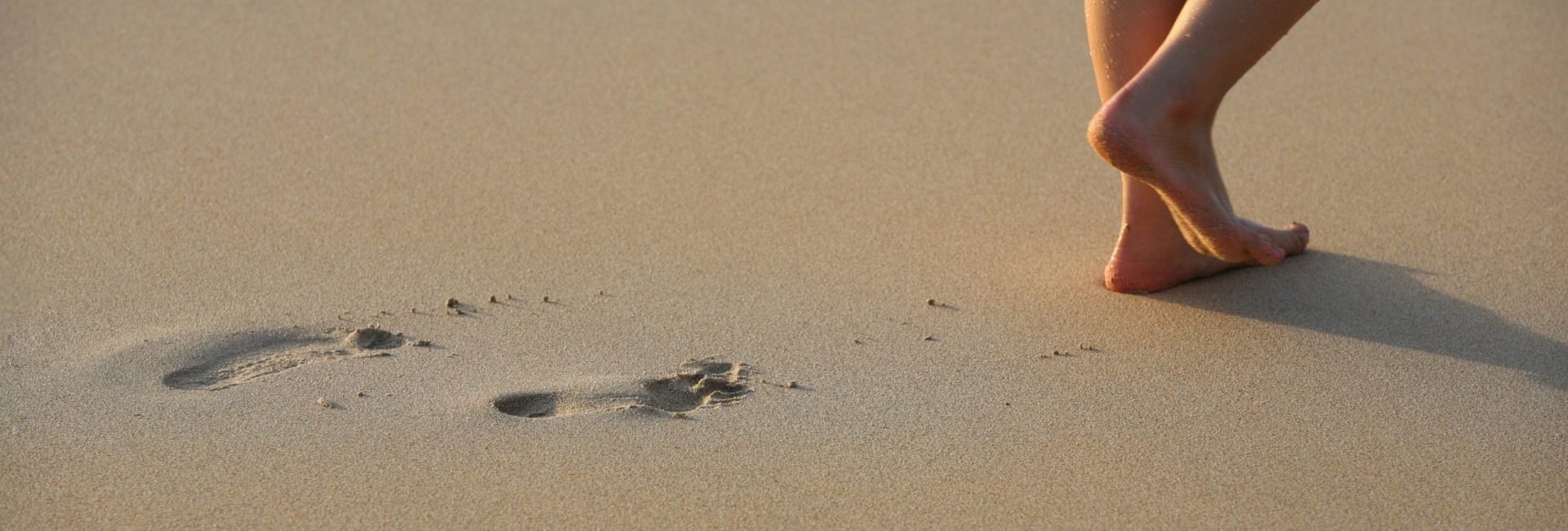 Image of foot prints and legs on beach