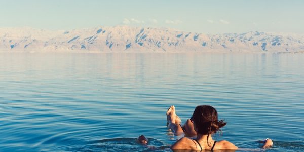 Girl is relaxing and swimming in the water of the Dead Sea in Israel