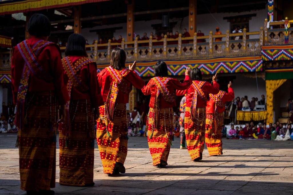 Bhutanese dancers in traditional attire perform at the Tshechu festival in Punakha.