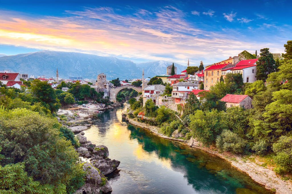 Fantastic Skyline of Mostar with the Mostar Bridge, houses and minarets, at sunset. Location: Mostar, Old Town, Bosnia and Herzegovina, Europe